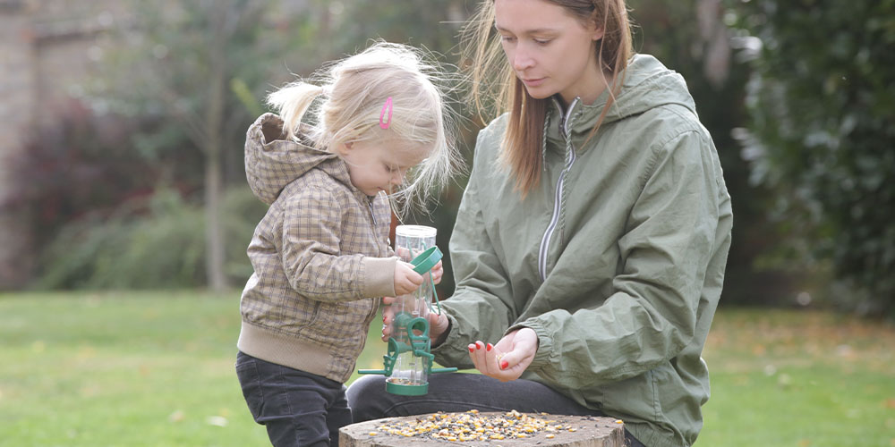 Dees Nursery -Check out Dee's Nuts and Feed the Birds -mother and daughter filling bird feeder
